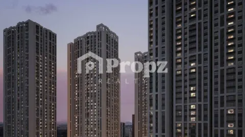 Modern high-rise residential towers with illuminated windows at Brigade Belvedere during twilight