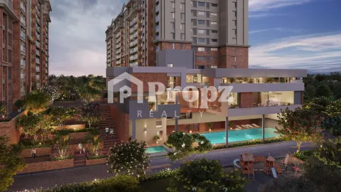 Clubhouse with swimming pool and children's play area surrounded by residential towers at dusk