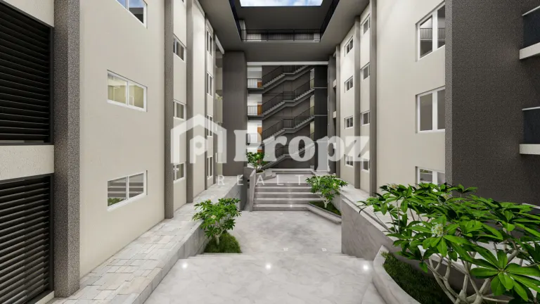Interior courtyard with paved walkway, planters, and staircase access to residential floors
