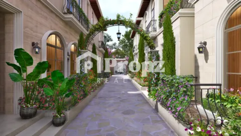Landscaped walkway between residential buildings with arched doorways, flowering plants, and decorative arch