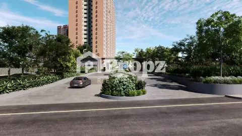 Landscaped entrance driveway with security gate and residential towers surrounded by greenery