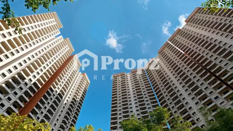 Upward view of modern residential tower facades with balconies and brown and white exterior panels