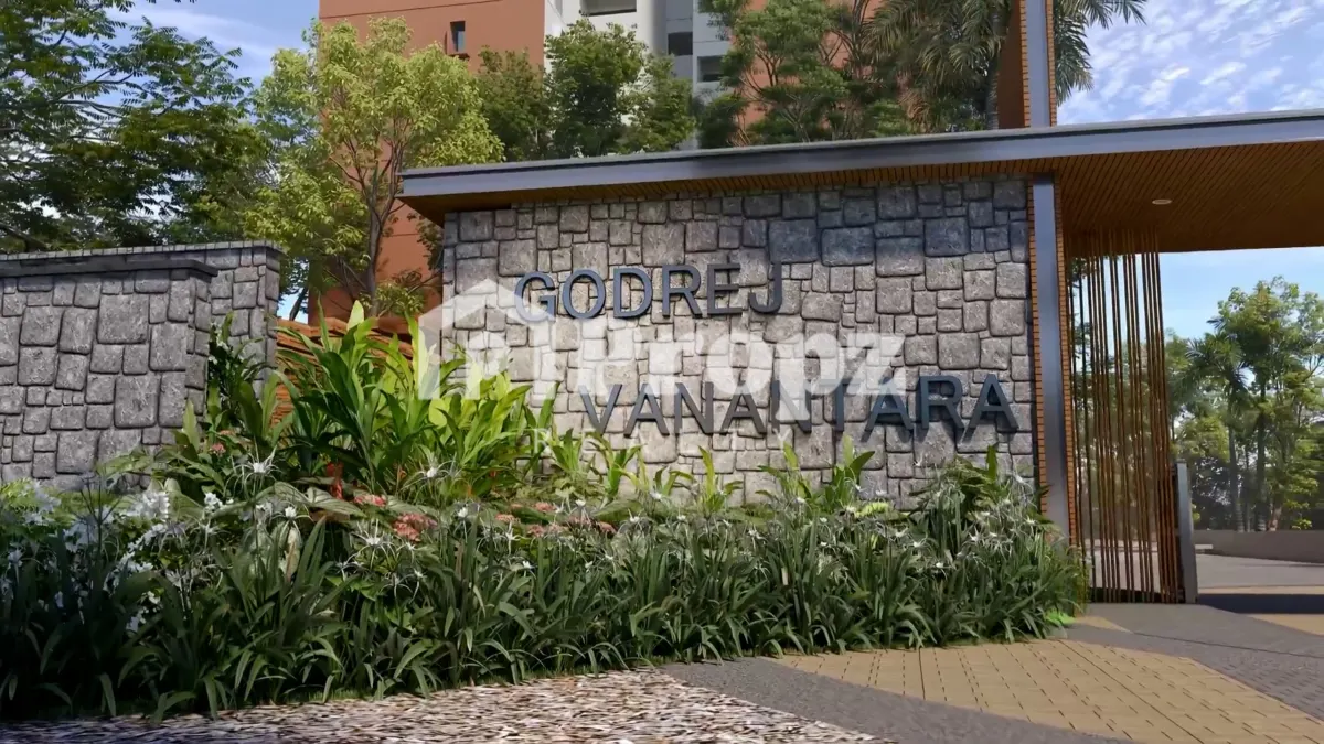 Godrej Vanantara entrance with stone wall signage and landscaped gardens with residential towers in background