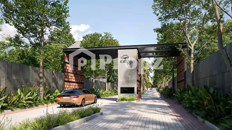 Entrance gate with Assetz Mizu and Ki signage surrounded by landscaped greenery and paved driveway