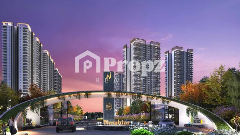Evening view of Nambiar District 25 Phase 3 entrance gate with illuminated residential towers in background
