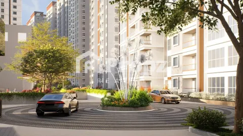 Entrance driveway with circular landscaping and modern residential towers in the background