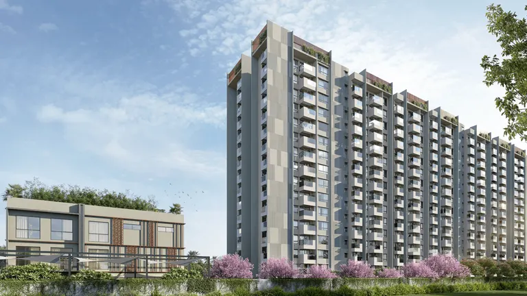 Modern residential towers with balconies and landscaped grounds featuring flowering trees at Capitol Residences