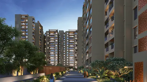 Landscaped walkway between illuminated residential towers at dusk with decorative brick screens