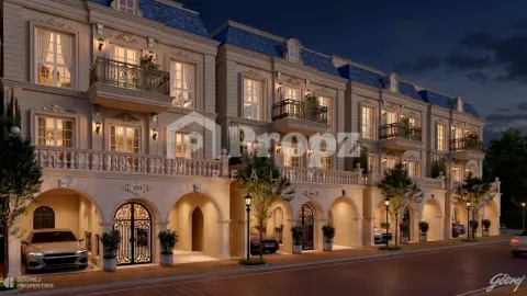 Evening view of illuminated Godrej Florenne townhomes with arched parking and decorative balconies