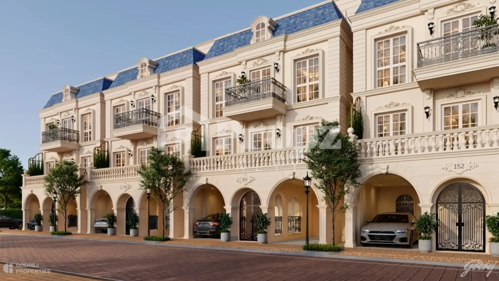 Godrej Florenne facade with cream-colored townhomes featuring blue mansard roofs and arched ground-level parking
