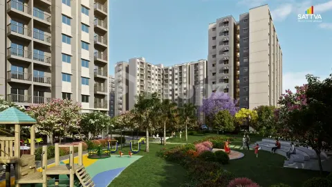 Landscaped courtyard with children's play area and flowering trees between residential towers at Sattva Aeropolis