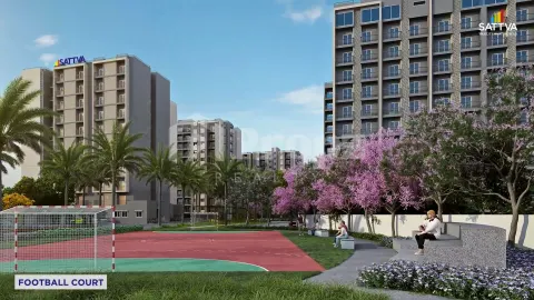 Football court with seating area and residential buildings surrounded by flowering trees at Sattva Aeropolis
