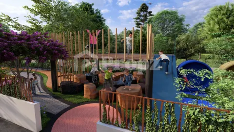 Children's play area with climbing structures and blue slide surrounded by greenery
